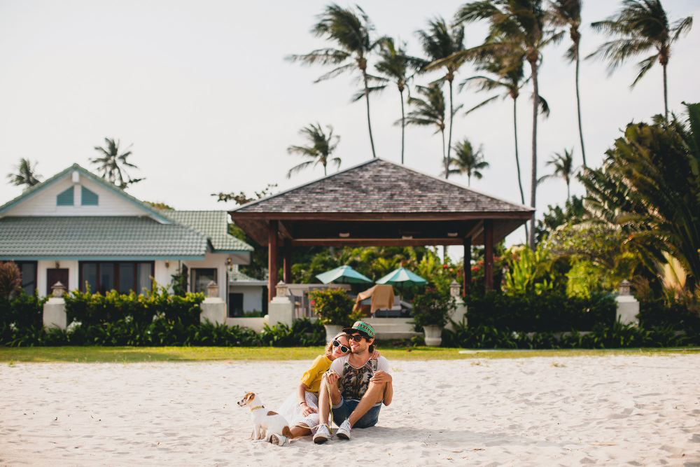 young stylish hipster couple love walking playing dog puppy jack russell tropical beach cool outfit romantic mood having fun sunny man woman together horizontal vacation house home villa